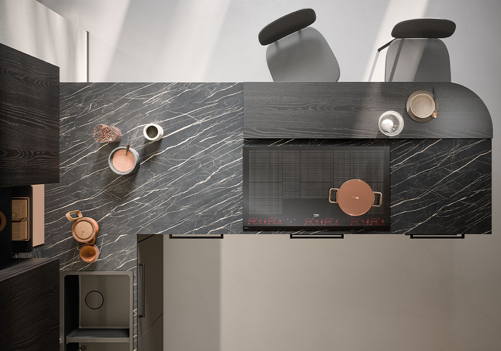 Piano cottura a induzione su top in gres nero dorato.